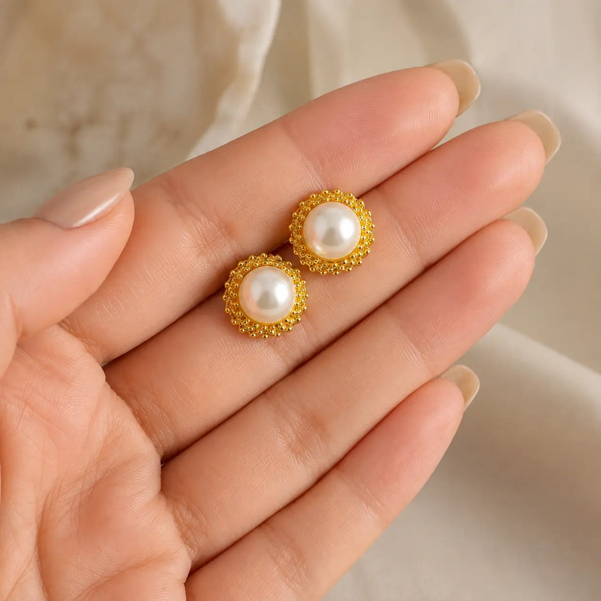Meher pearl halo studs handheld scale view